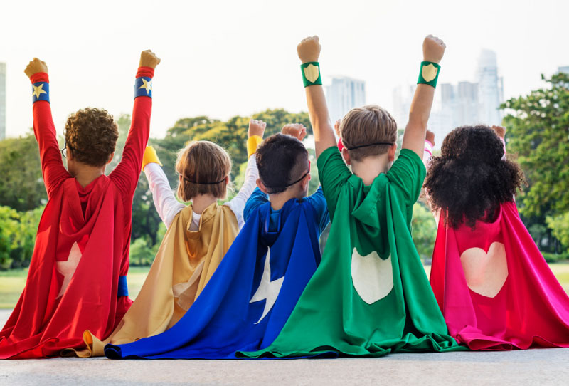 young children wearing superhero capes